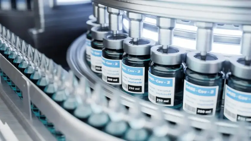 Automated pharmaceutical production line filling vaccine vials in sterile environment for cold chain storage and distribution